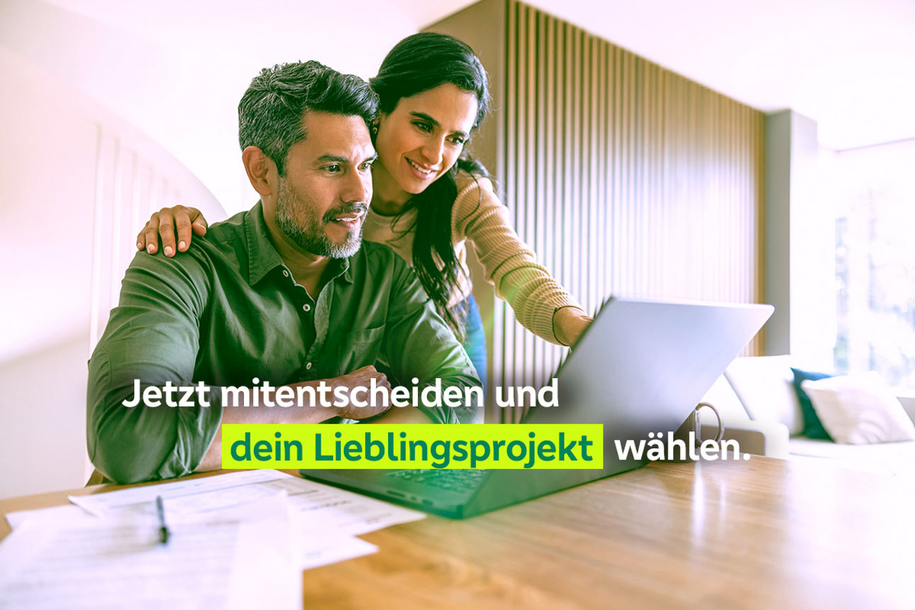 Mann und Frau sitzen vor dem Laptop und treffen eine Entscheidung.