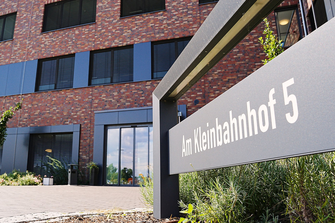 Abbildung eines Hauses mit Straßenschild " Am Kleinbahnhof 5"