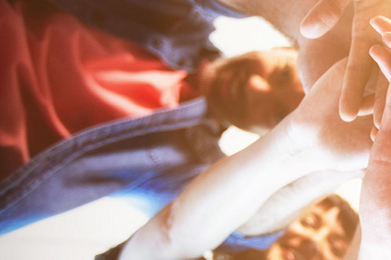 Eine Gruppe junger Menschen, die sich gegenseitig die Hände auflegen