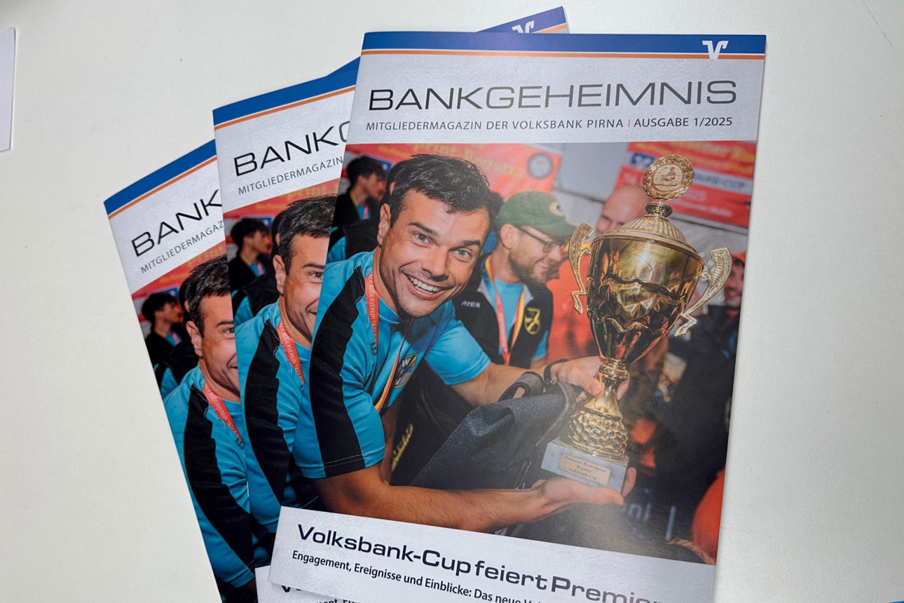 6 Menschen im Innenraum stehen nebeneinander, teilweise in Anzügen, Bankchef Dr. Hauke Haensel gratuliert einer jungen Frau