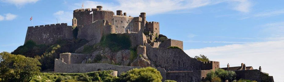 Ein malerisch auf einem Hügel gelegenes Schloss, umgeben von einem strahlend blauen Himmel, der seine historische Bedeutung u