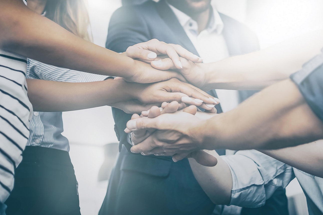 Zwei kleine Mädchen spielen mit Strohhalmen und ihre Mutter behält sie im Auge