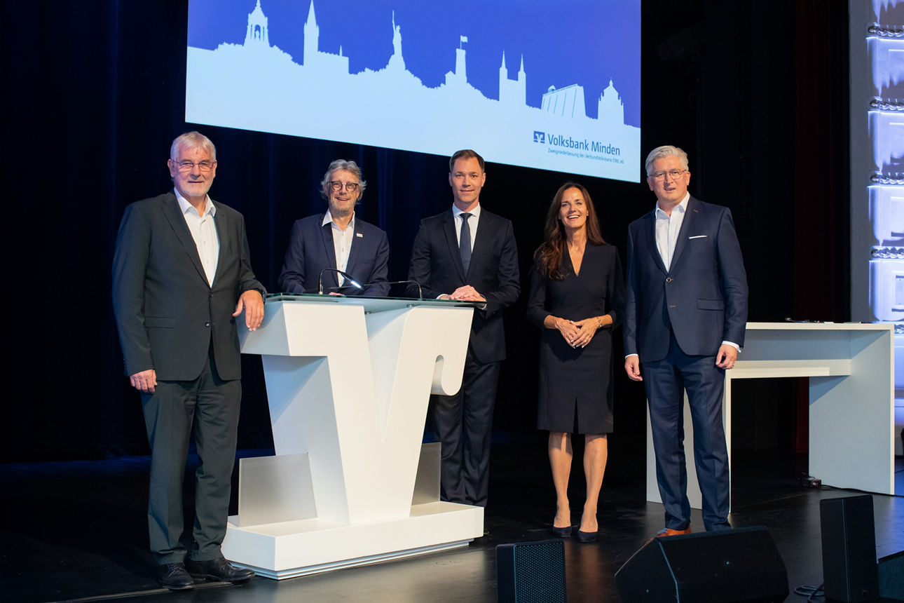 Die Protagonisten der Mitgliederversammlung der Volksbank Minden stehen auf der Bühne