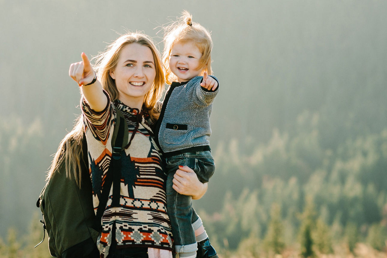 Mutter hält Tochter bei Wanderung auf ihrem Arm