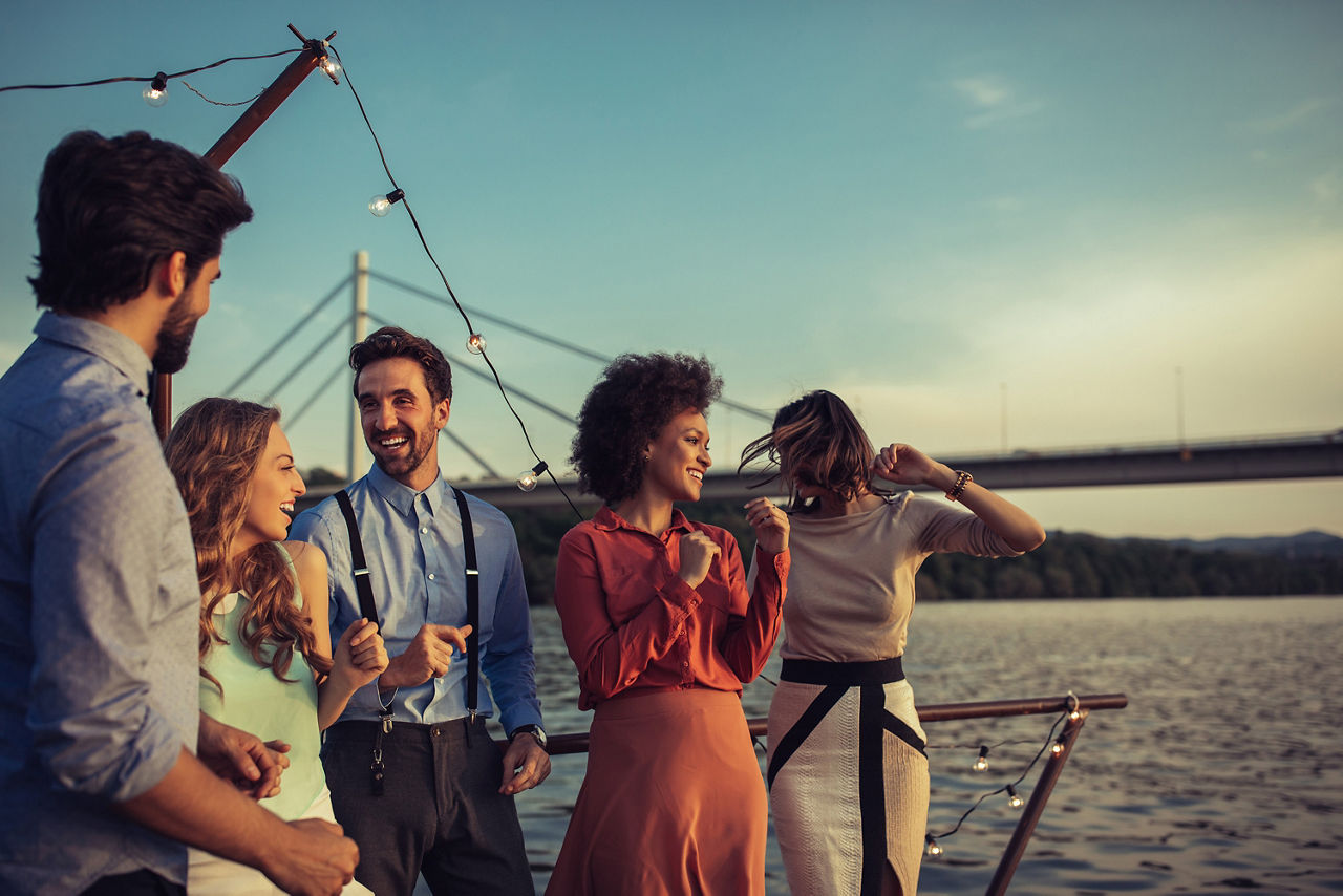 5 Menschen stehen auf einer Brücke und feiern