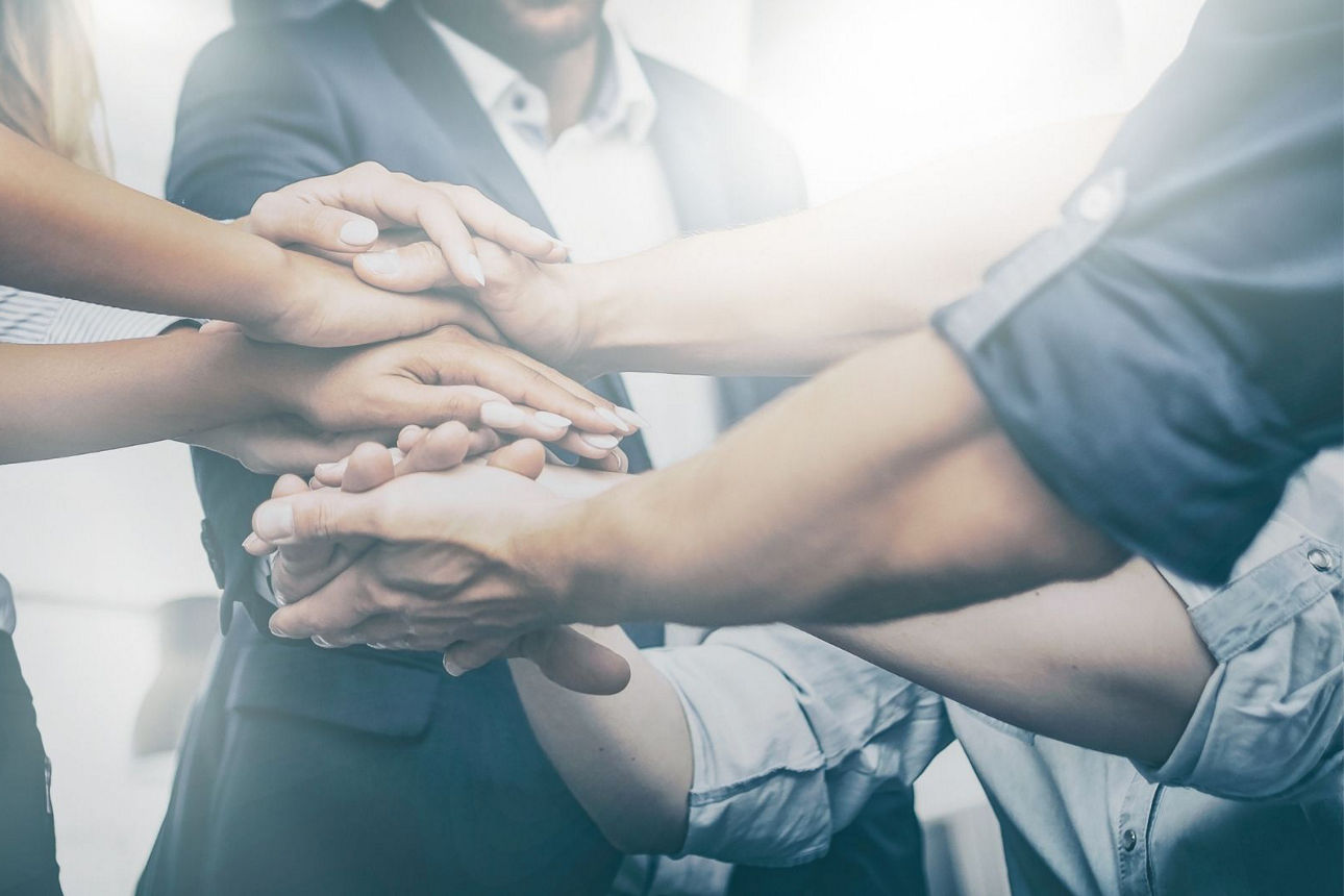 Menschen legen die Hände übereinander