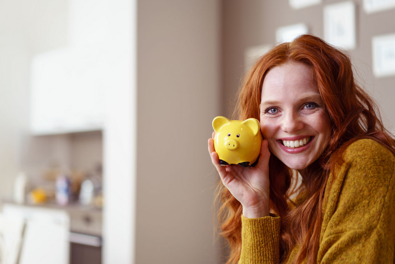 Frau mit gelben Sparschwein