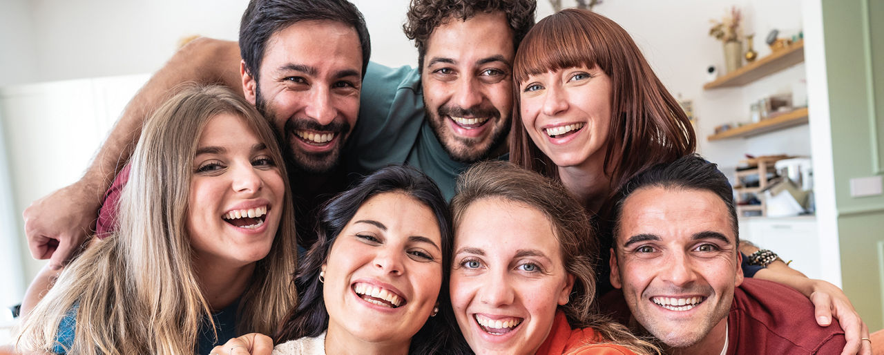 Gruppe junger Menschen macht ein gemeinsames Selfie in der WG