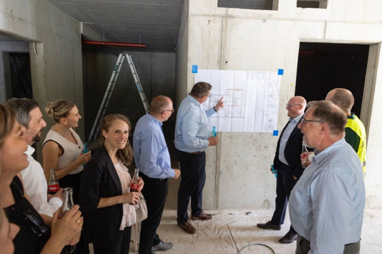 Gemeinsam schauen die Mitarbeitenden der Volksbank auf den Bauplan 