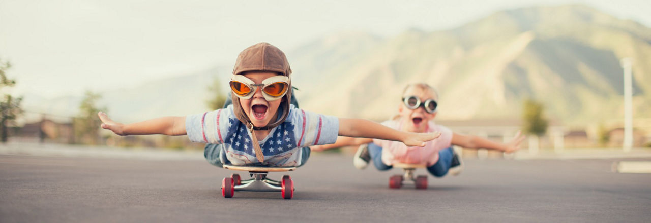 Kinder liegend auf Skateboard