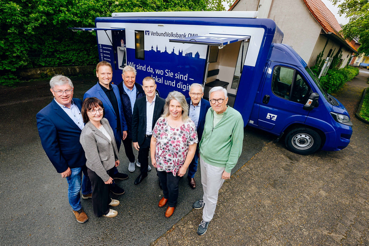 Das Team der mobilen Filiale steht vor dem Volksbank-Bus.