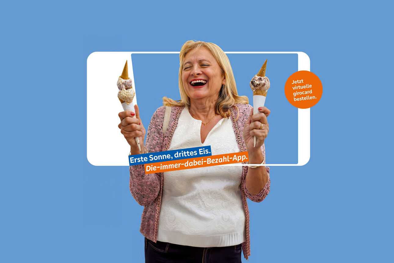 Lachende Frau mit je einer Eiswaffel in den Händen, die dirch einem Smartphonerahmen schaut.