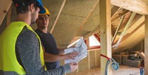 Zwei Männer auf einer Baustelle lesen einen Plan