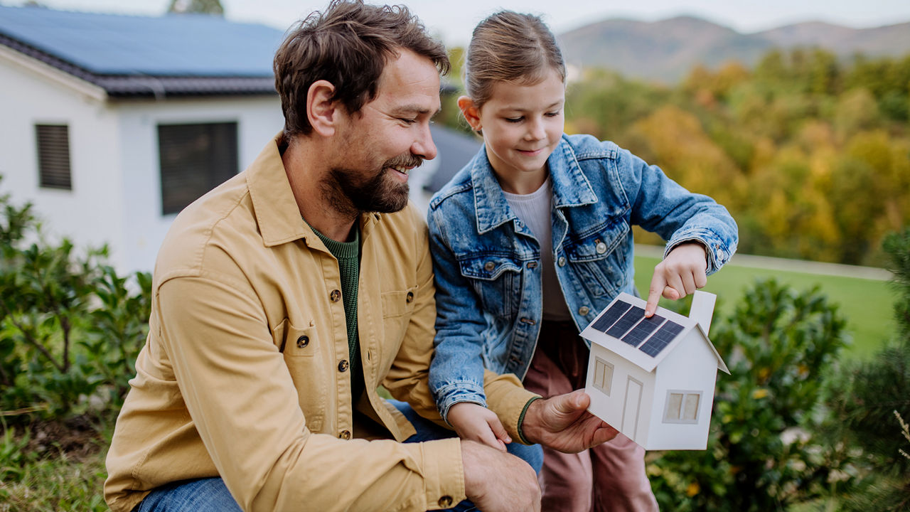 Vater und Tochter zeigen auf ein Solarmodul