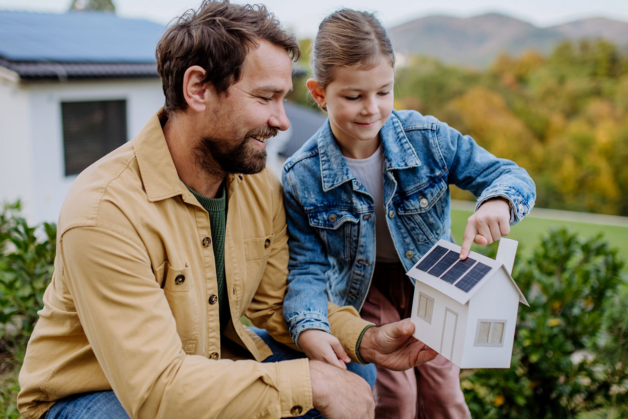 Vater und Tochter zeigen auf ein Solarmodul