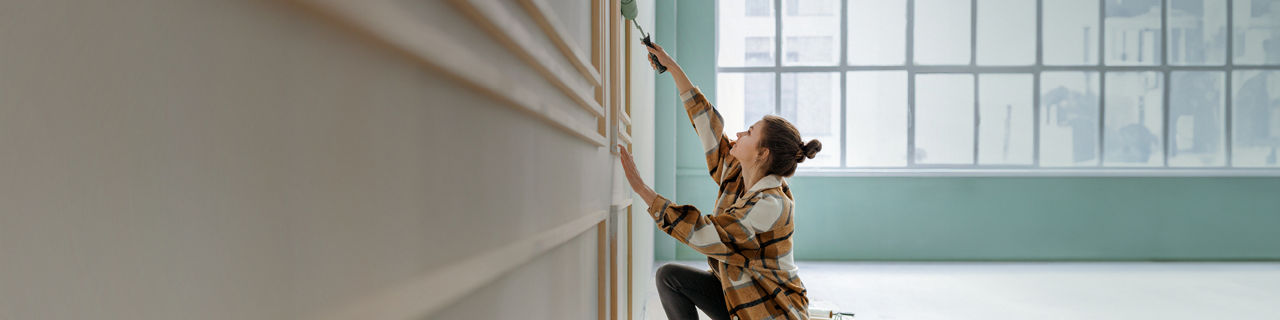 Junge Frau streicht eine Wand