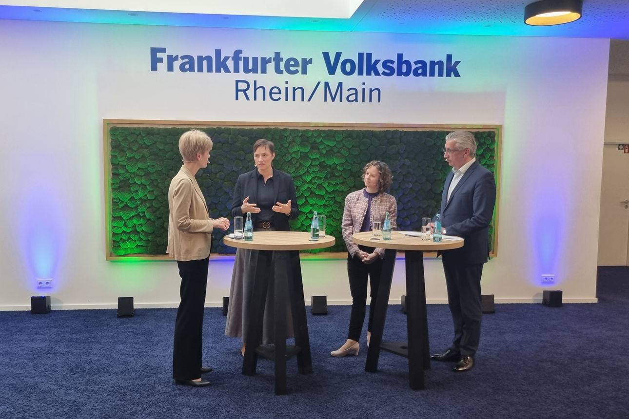 Zwei Frauen und zwei Männer im Austausch vor einer Mooswand