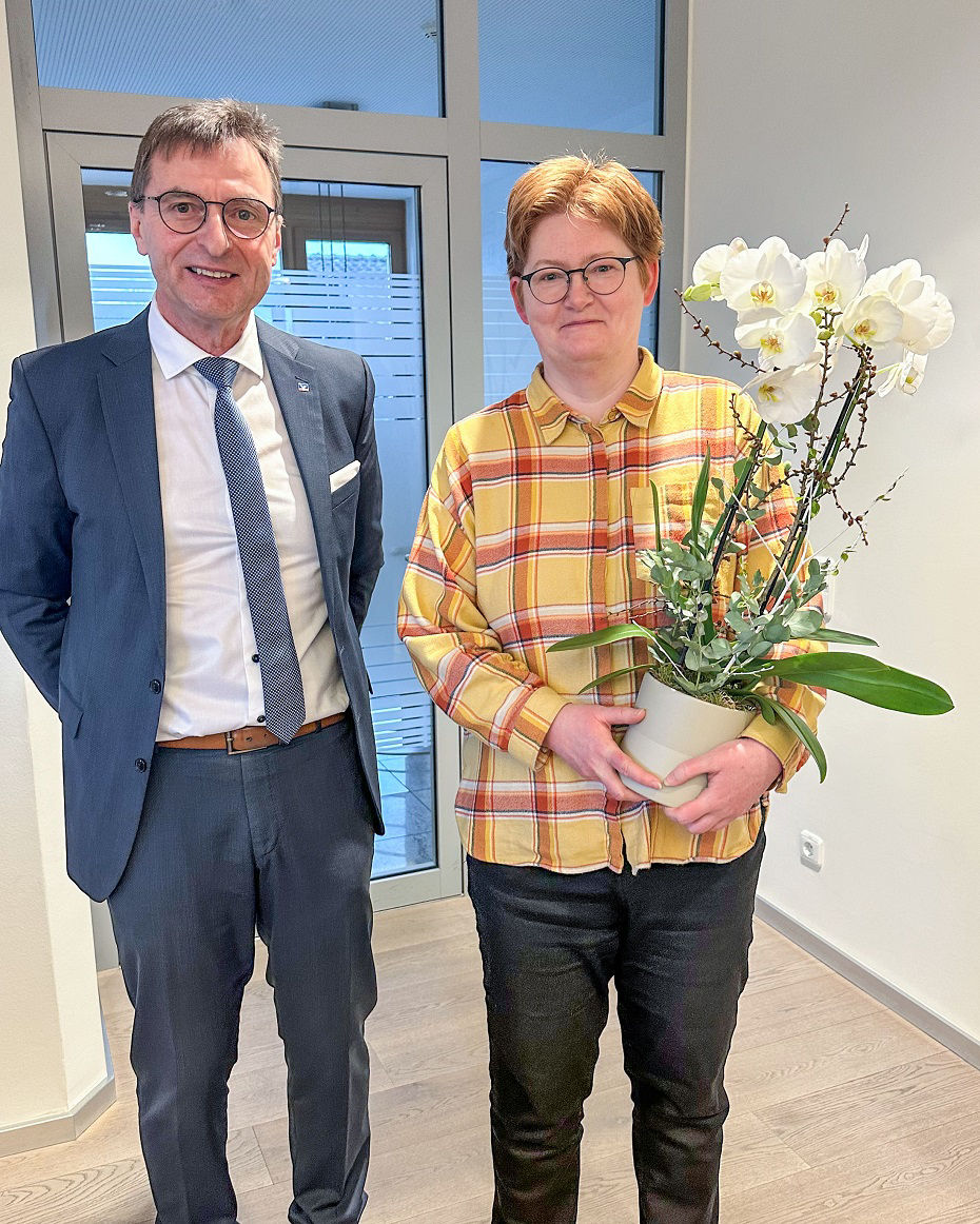 Ein Mann steht neben einer Frau, die eine Orchidee in der hand hält
