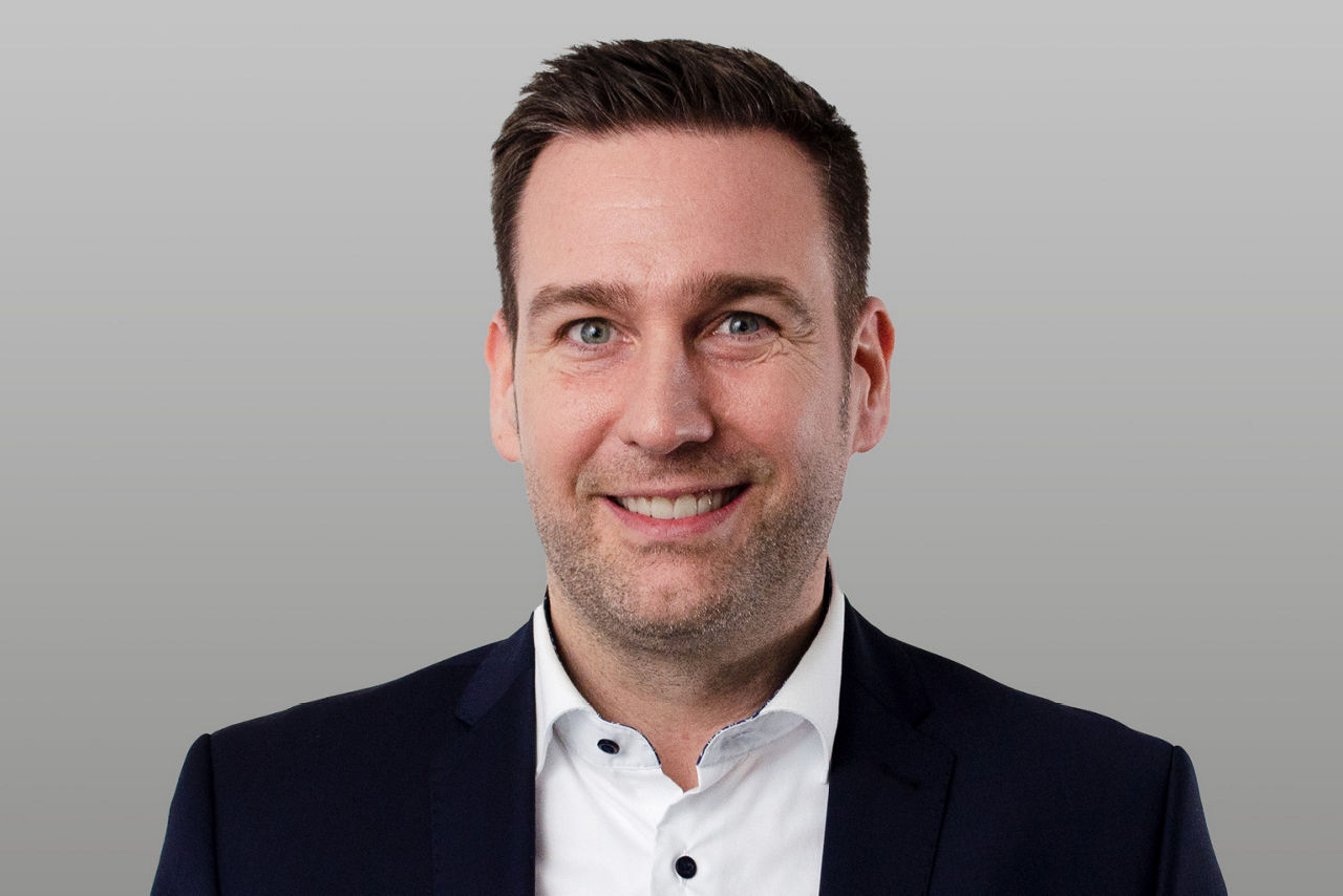 Privatkundenberater Jan Morgenweg vor grauen Hintergrund