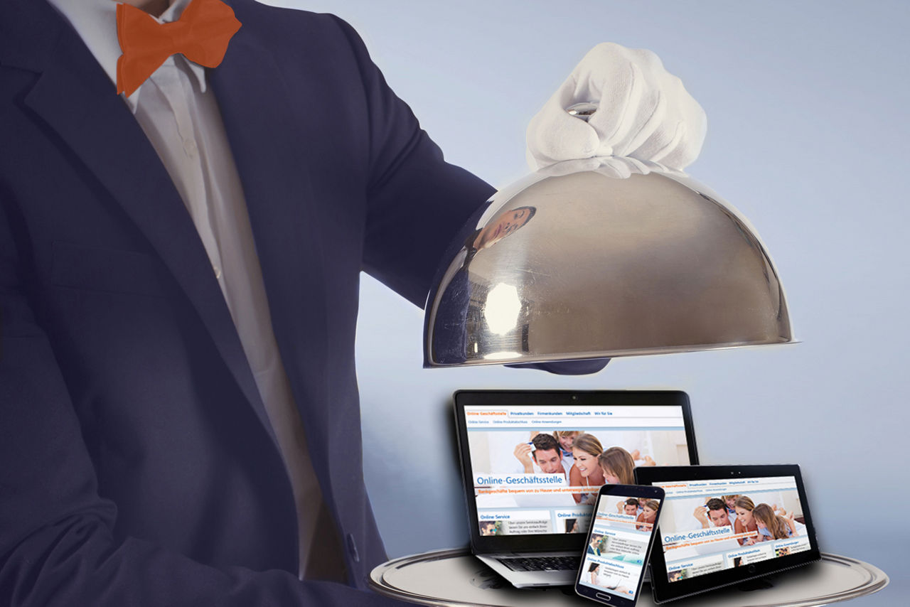Butler hebt Haube hoch - darunter befinden sich ein Laptop, ein Smartphone und ein Tablet