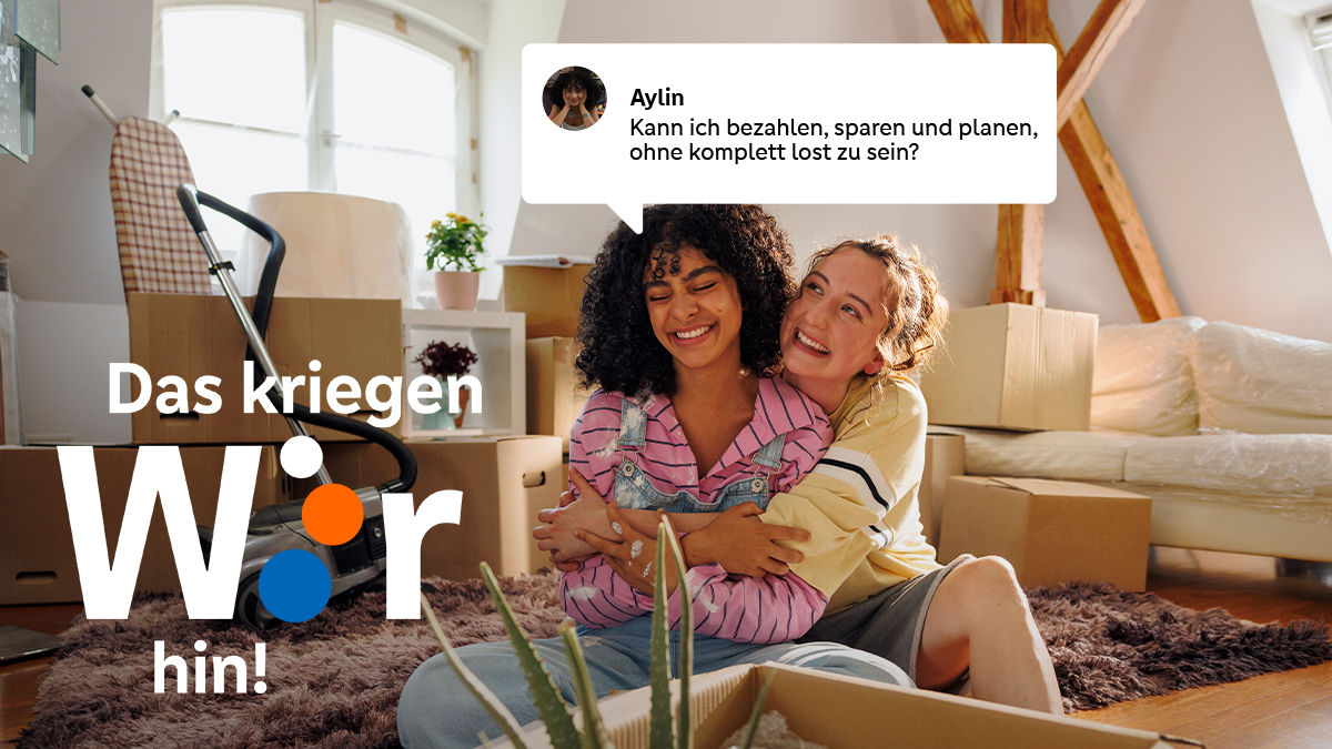 Zwei junge Mädchen umarmen sich im Sitzen in der neuen Wohnung.