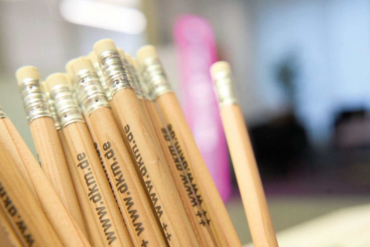 Im Vordergrund sind einige Bleistifte zu sehen, der Hintergrund ist verschwommen