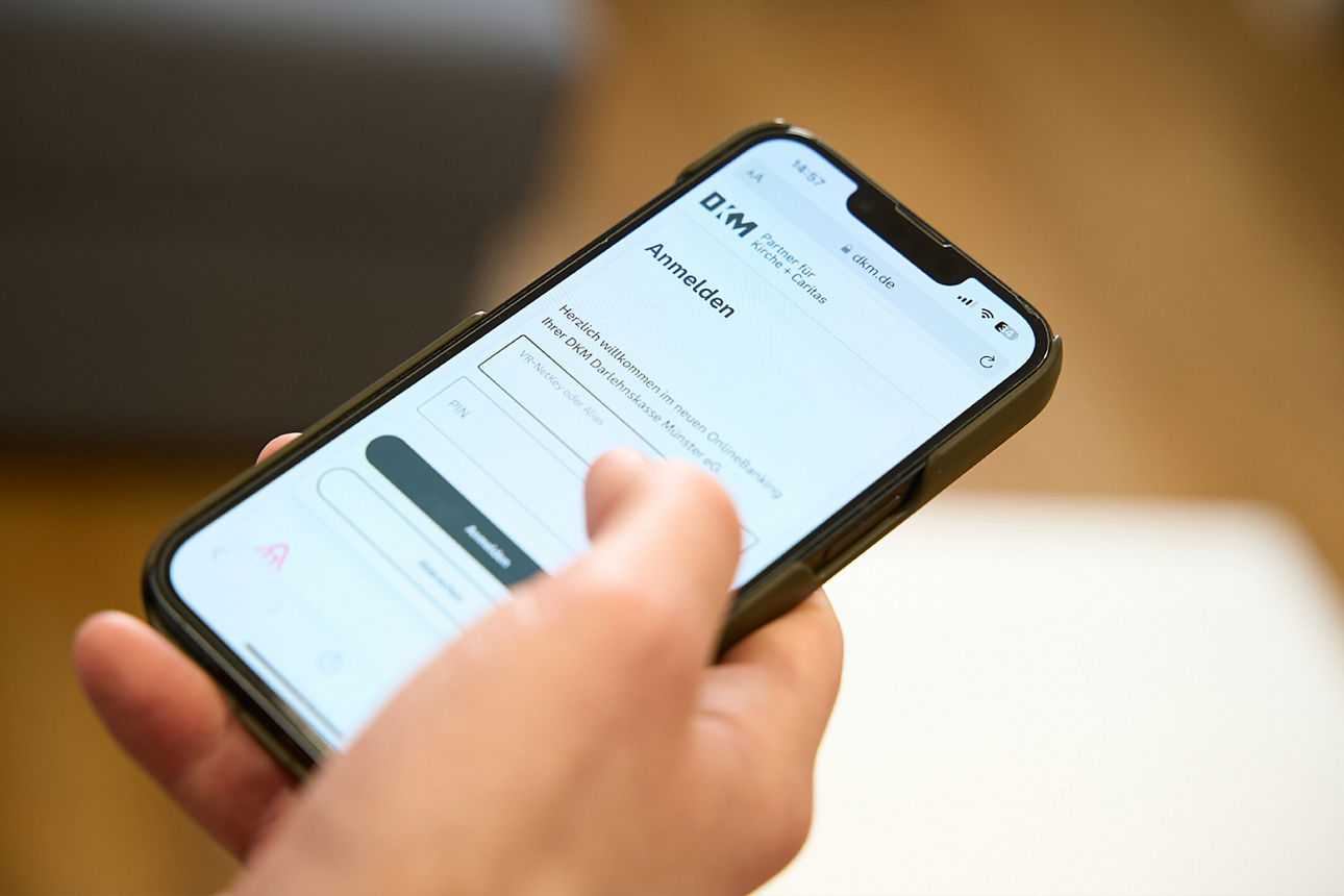 Person loggt sich auf Konto im Handy ein