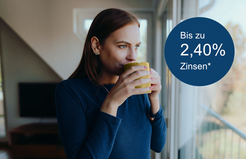 Frau steht mit Kaffeetasse in den Händen am Fenster daneben blauer Kreis mit dem Text: Bis zu 2,40 % Zinsen*