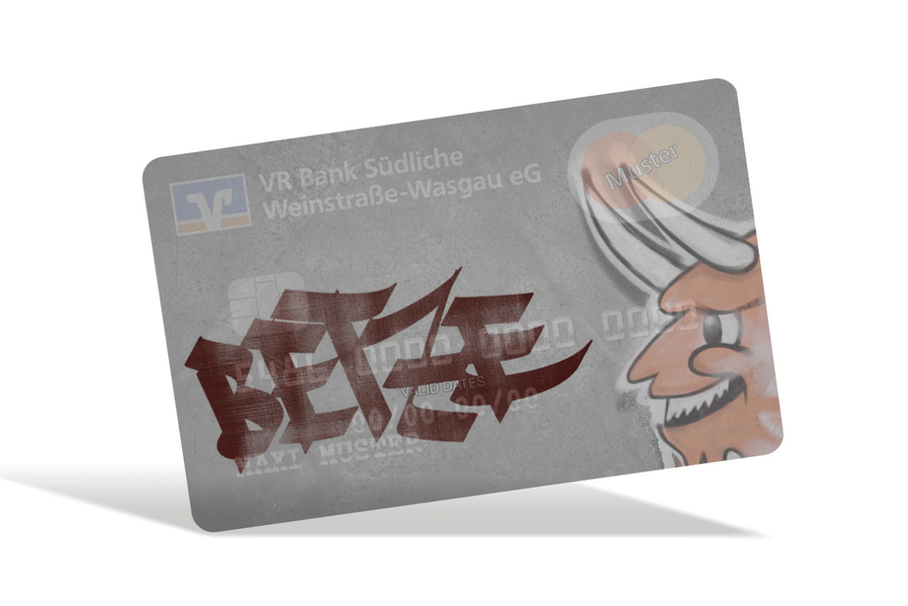 Graue Kreditkarte der VR Bank mit großem „BEtze“-Schriftzug, Teufelsmotiv an der Seite und „Muster“-Beschriftung..