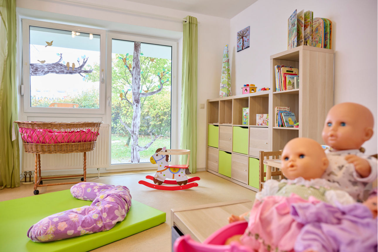 Bild zeigt ein Spielzimmer mit zwei Puppen im Vordergrund