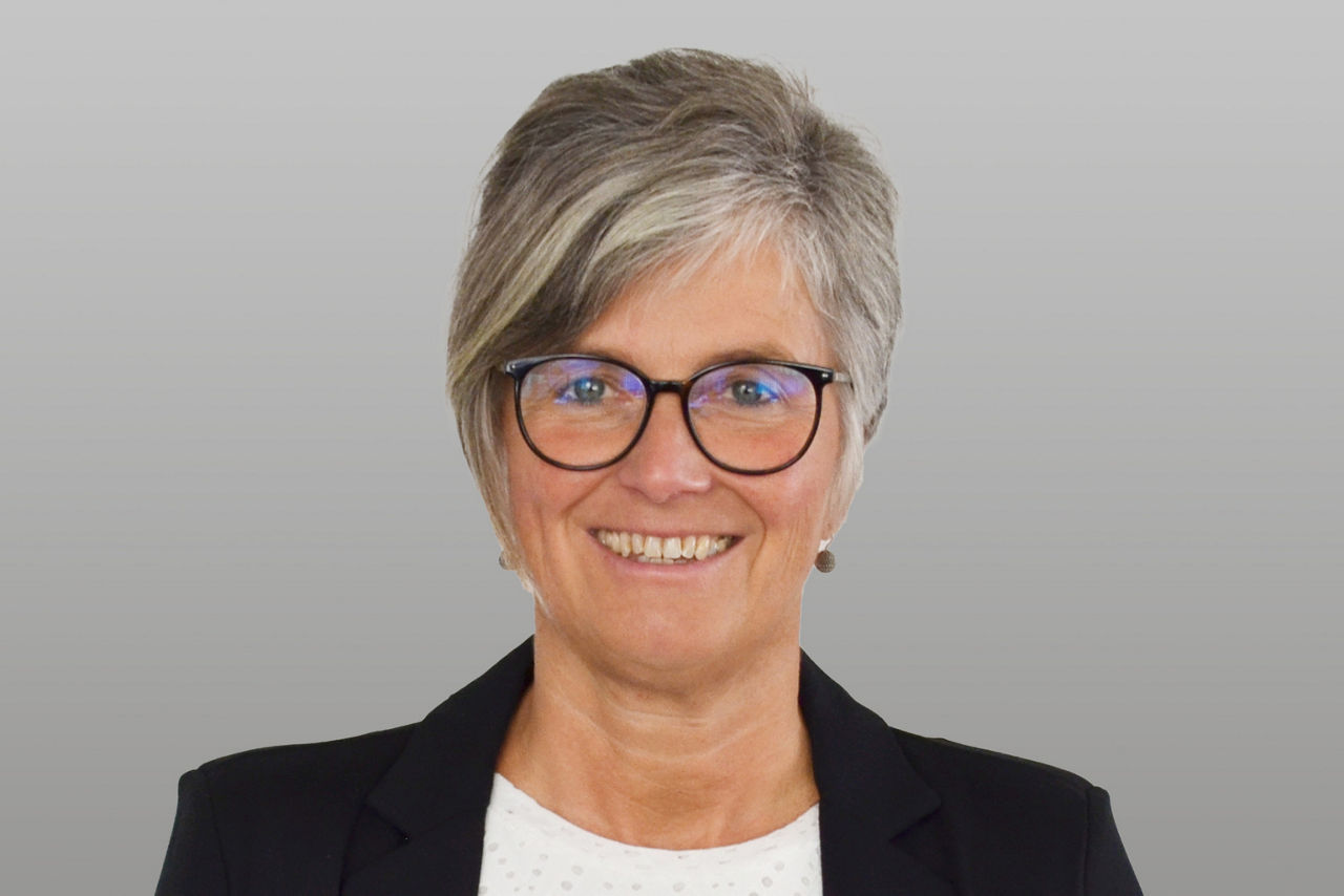 Privatkundenberaterin Anke Müller vor grauen Hintergrund