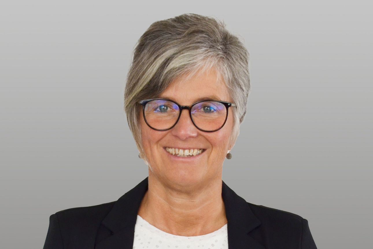 Privatkundenberaterin Anke Müller vor grauen Hintergrund