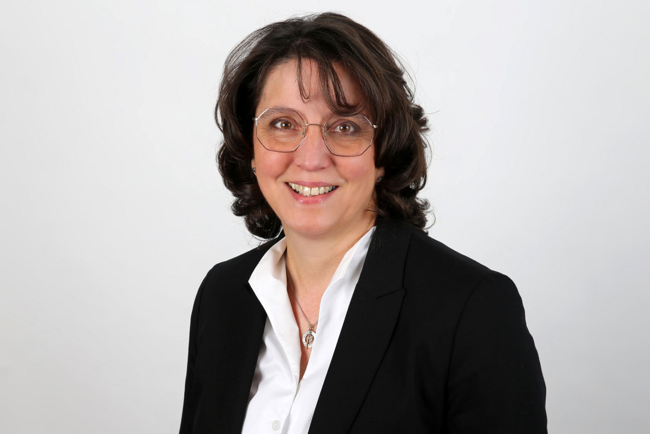 Eine lächelnde Frau schaut in die Kamera.
