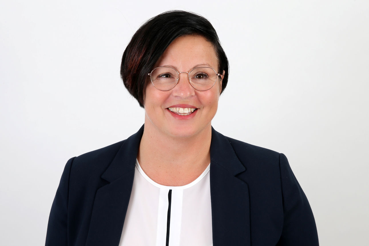 Eine lächelnde Frau schaut in die Kamera.