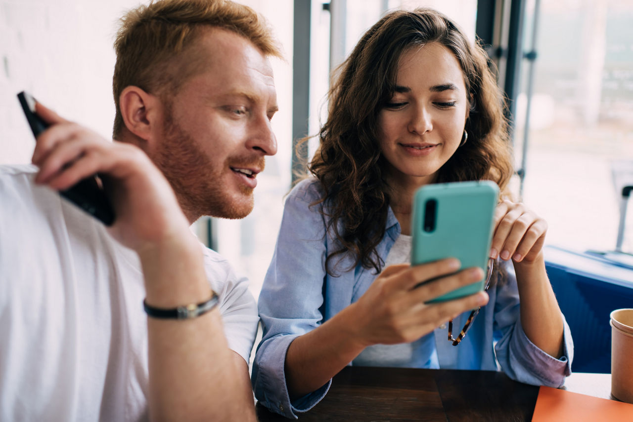 Ein Mann und eine Frau schauen gemeinsam auf ein Handy