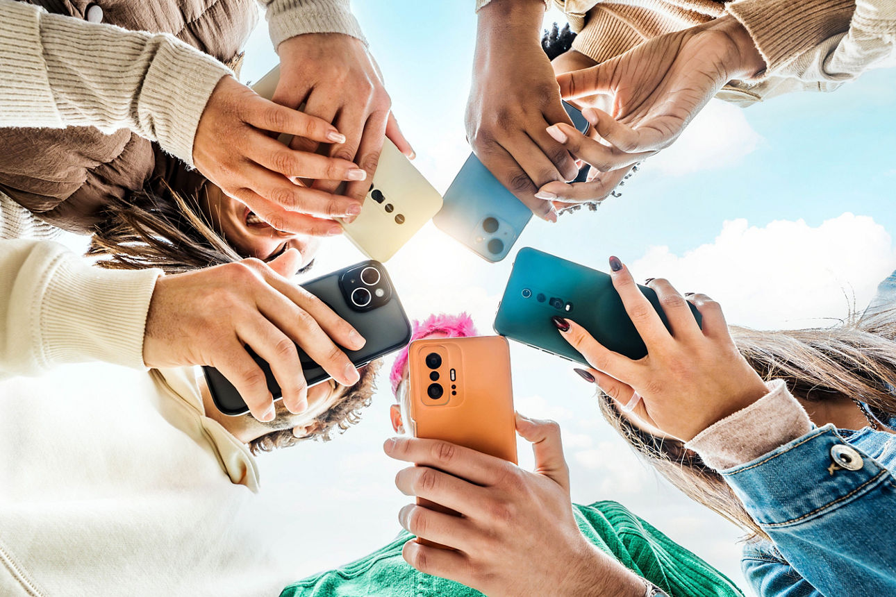 Mehrere Hände mit Smartphones bilden einen Kreis