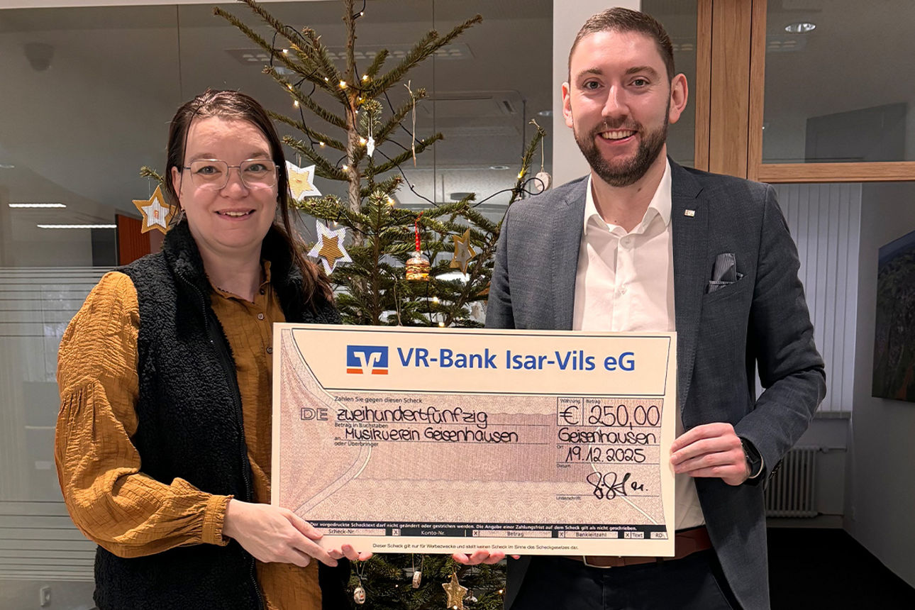 Eine Frau und ein Mann lächeln in die Kamera. Sie halten einen Riesenspendenscheck in der Hand.