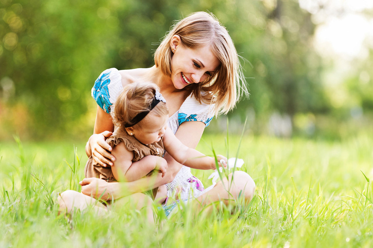 Mutter mit kleinem Kind auf einer Wiese