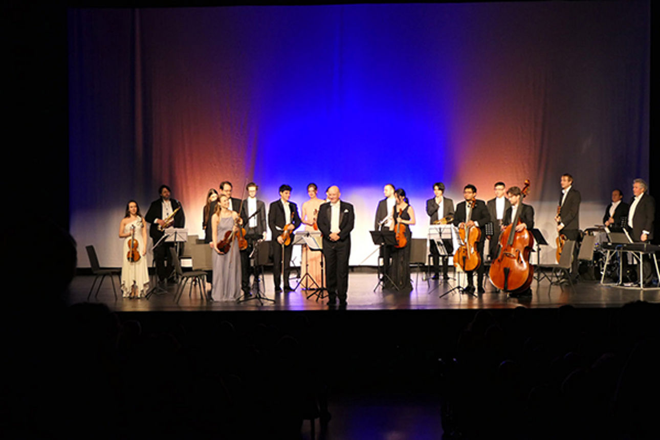 Eine Gruppe von Musikern mit Instrumenten auf einer Bühne.