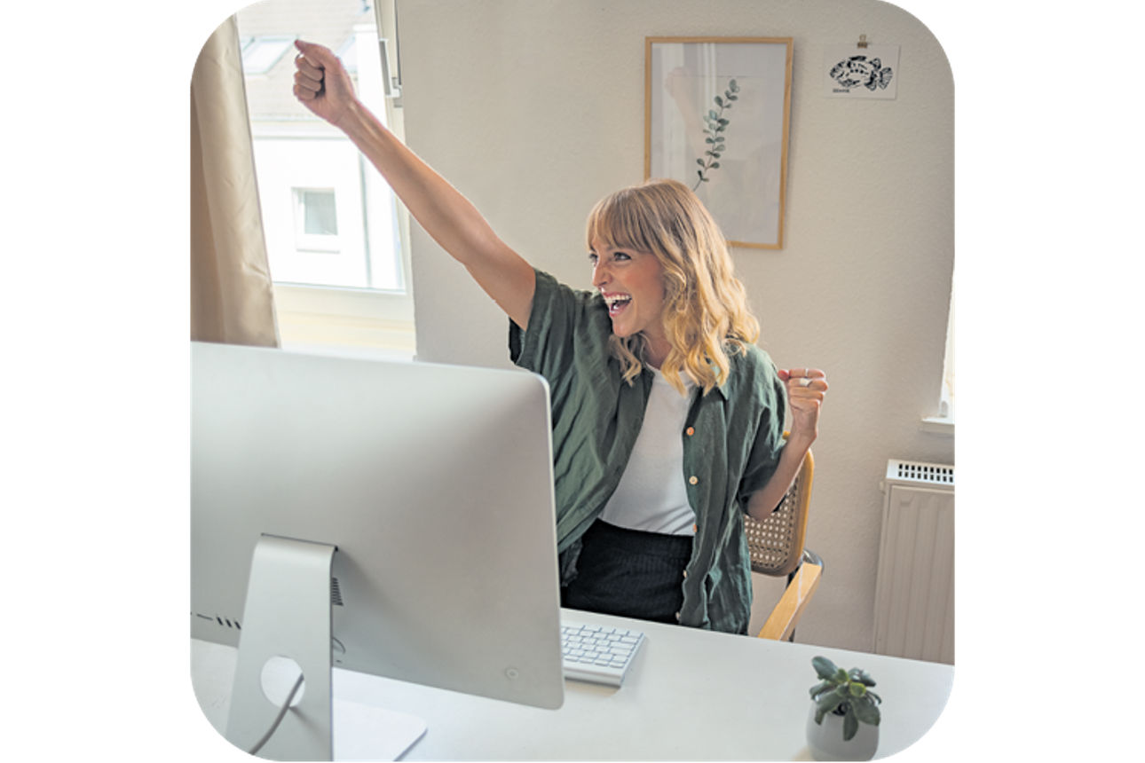 Frau freut sich vor Computer
