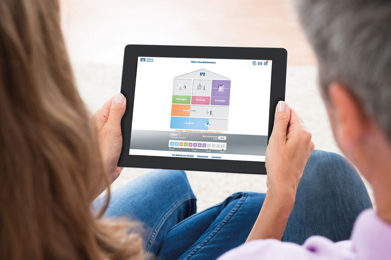 Couple Looking At House Photo On Digital Tablet