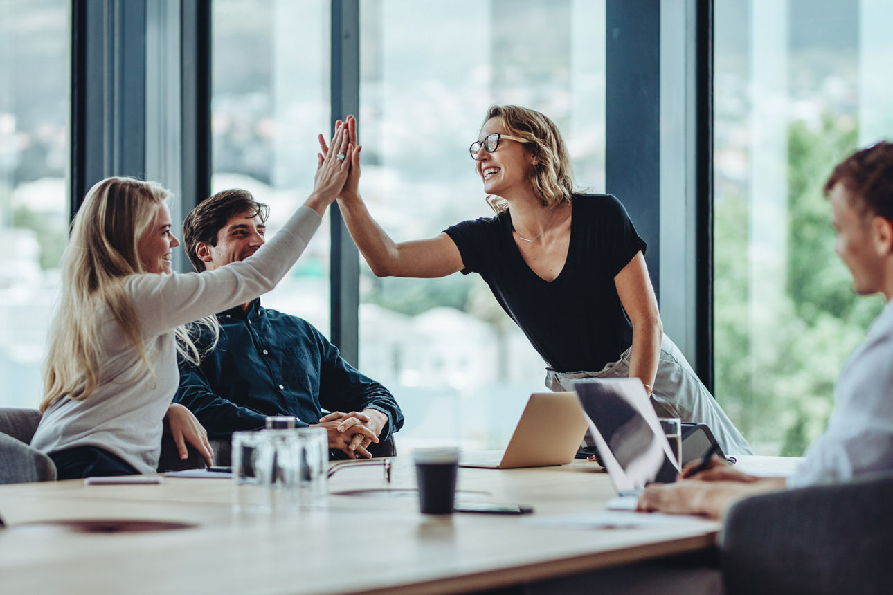 Gruppe von Kollegen feiert einen Erfolg im Teammeeting