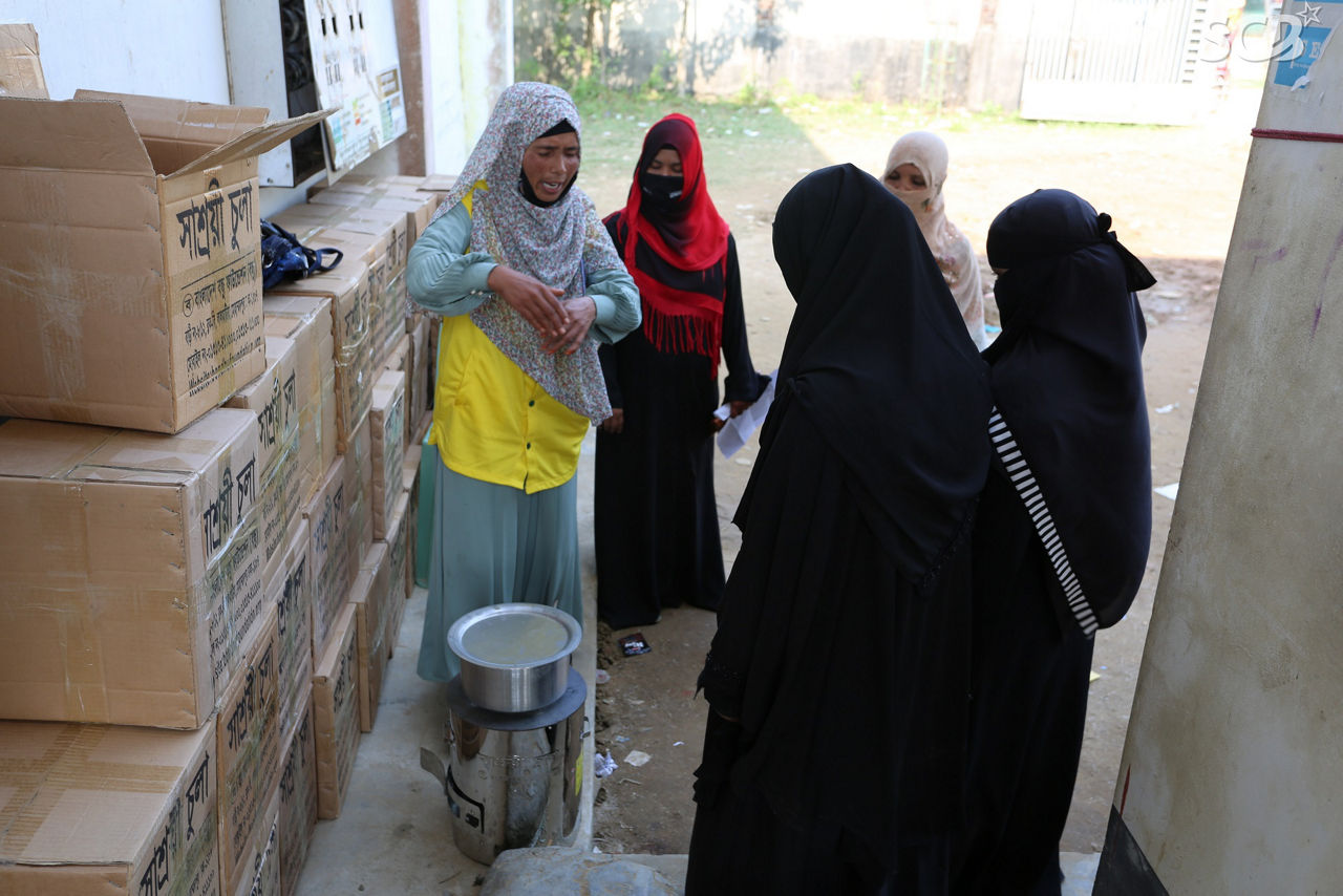 Fünf Frauen stehen in Bangladesch vor dem ausgepackten Kochofen.