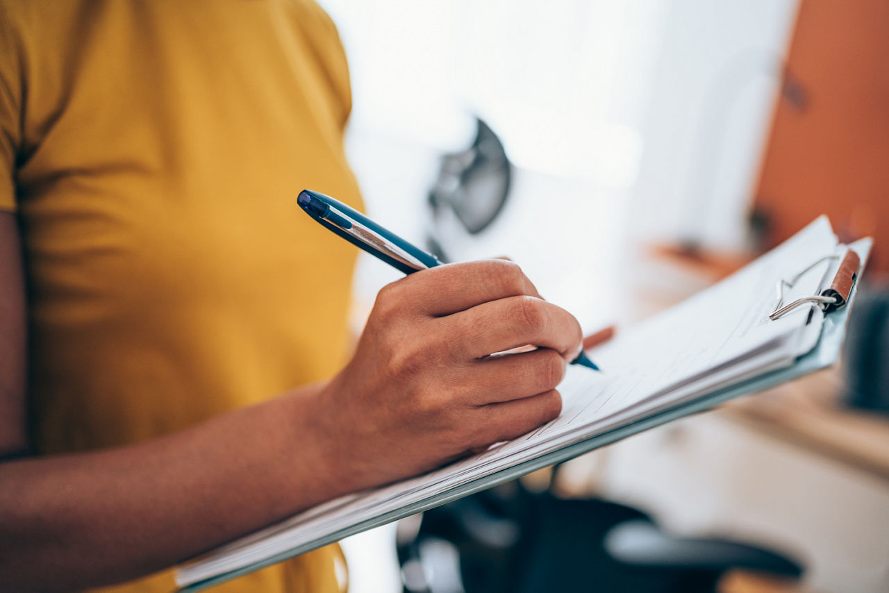 A person writing something on a piece of paper