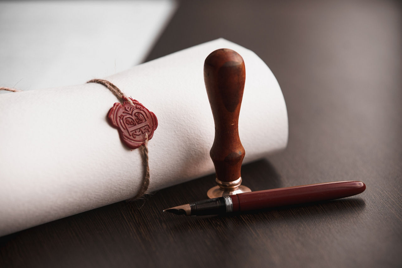 eingerollter Vertrag mit einem Stift und einem Notarsiegel