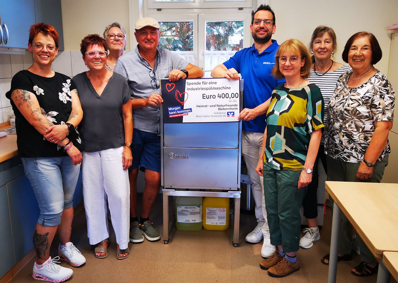 Erwachsene halten einen Spendenscheck in der Hand.