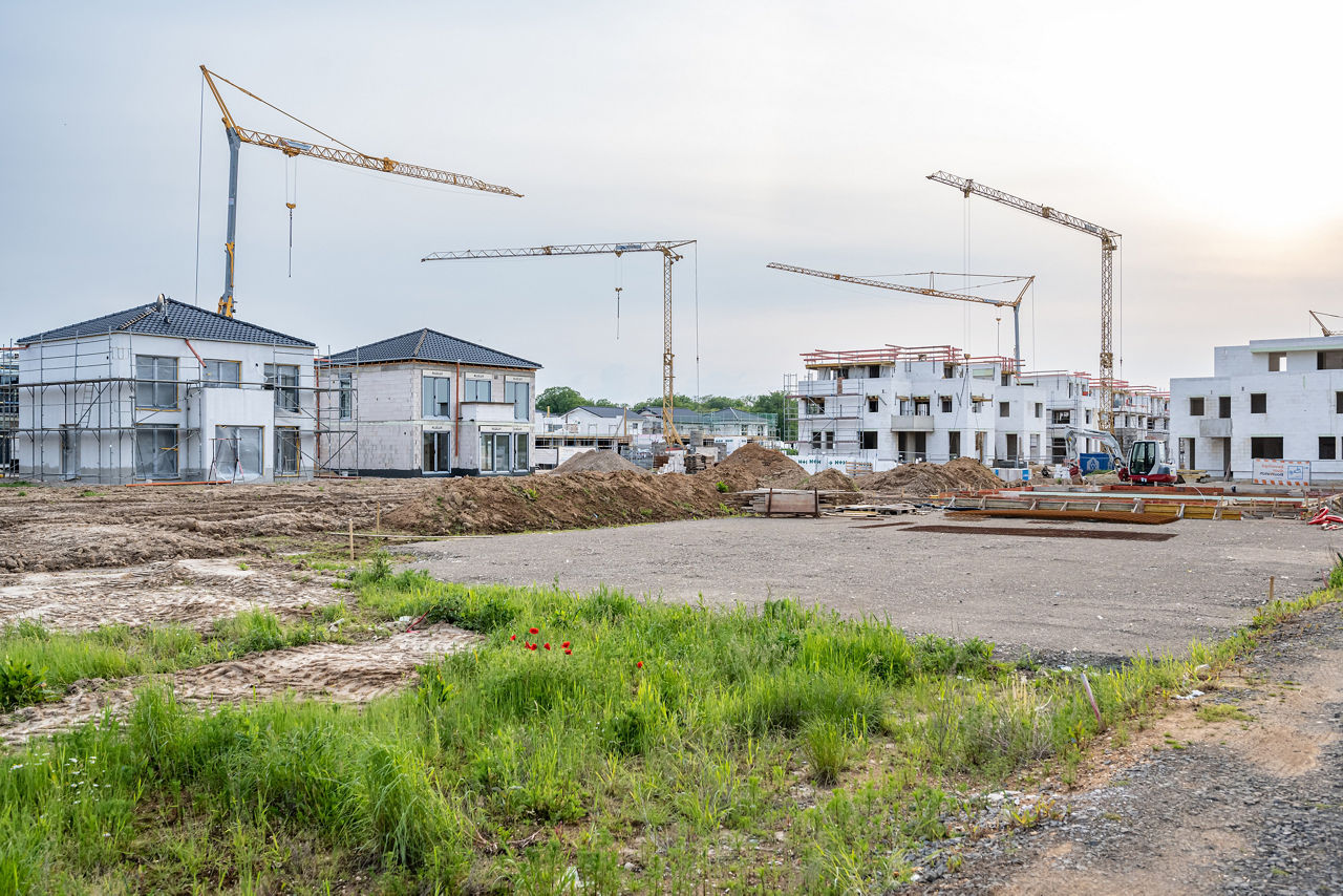 Neubaugebiet mit Häusern und Baukränen