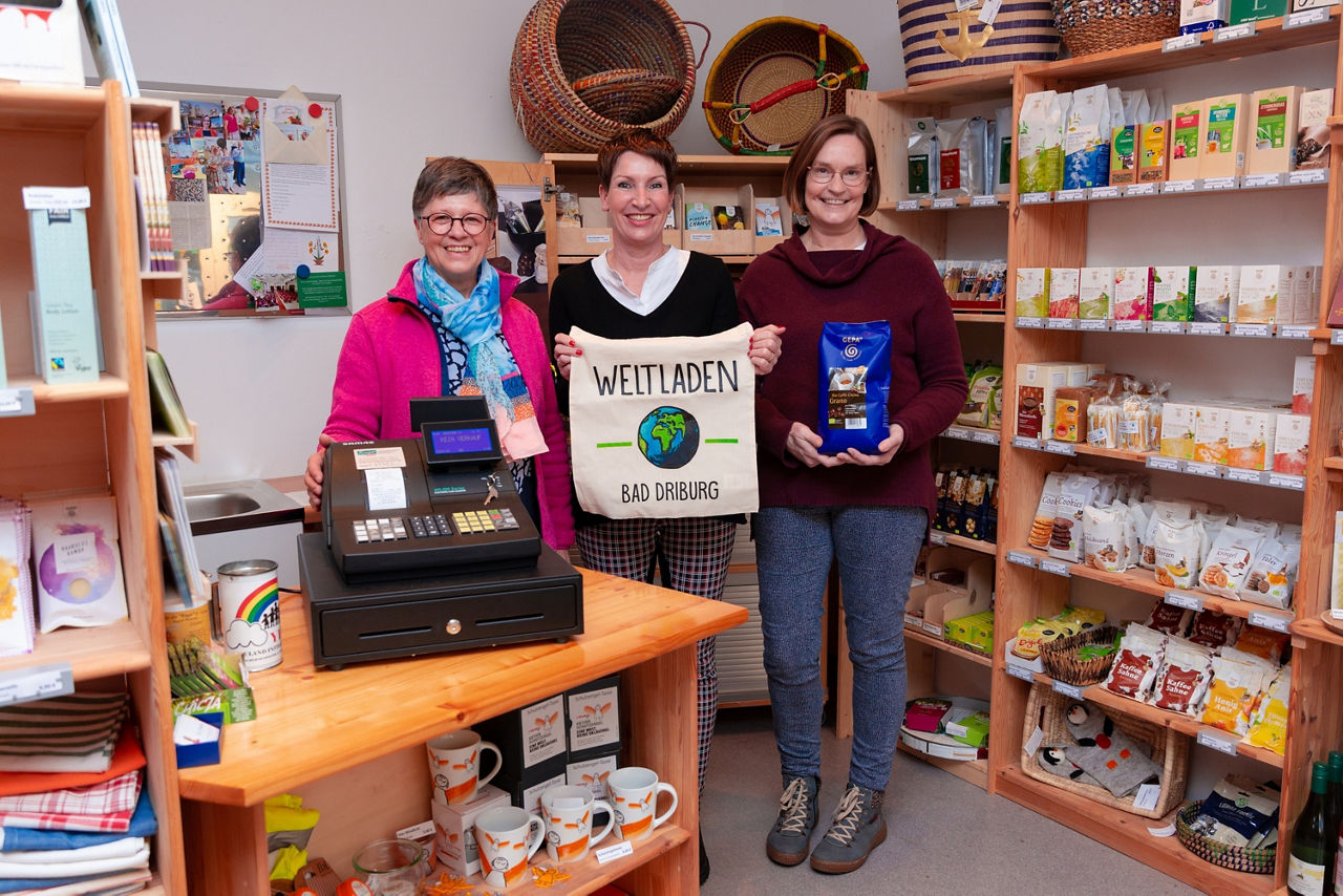 3 Personen, die eine neue Kasse im Weltlden einweihen