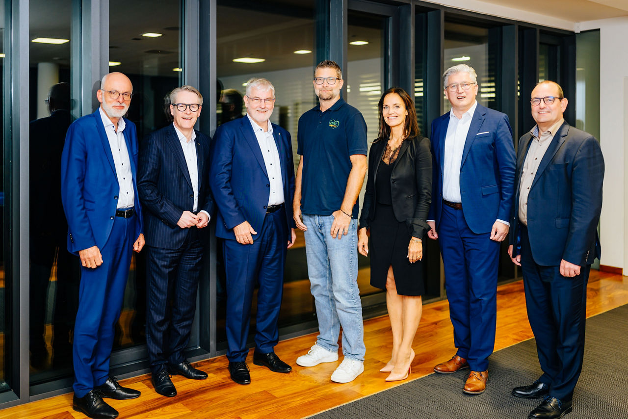 Mitglieder der VerbundVolksbank OWL Stiftung und Vorsitzende des Vereins OWL zeigt Herz e. V. stehen in den Räumlichkeiten der VerbundVolksbank OWL eG