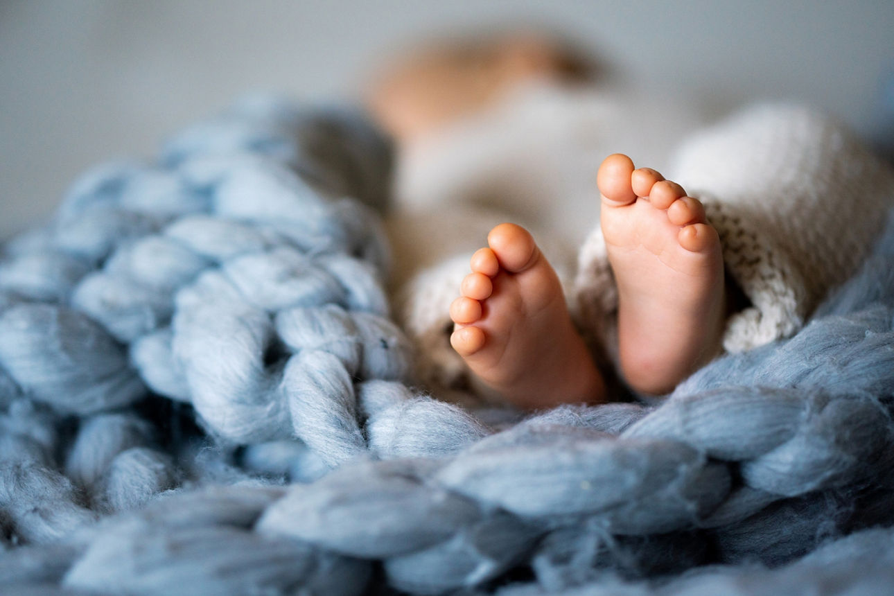 Baby liegt auf Decke